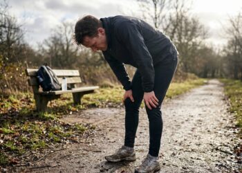 Sporter zet lichte schijven op een halterstang bij de eerste training na een pauze